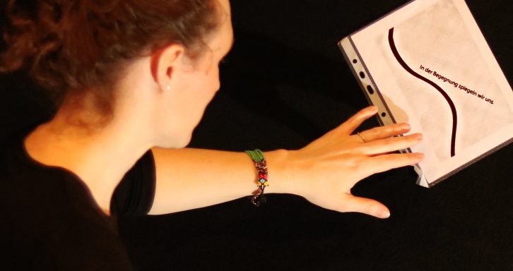 Textausschnitt  mit einer Wellenbewegung unterstrichen: "In der Bewegung begegnen wir uns"